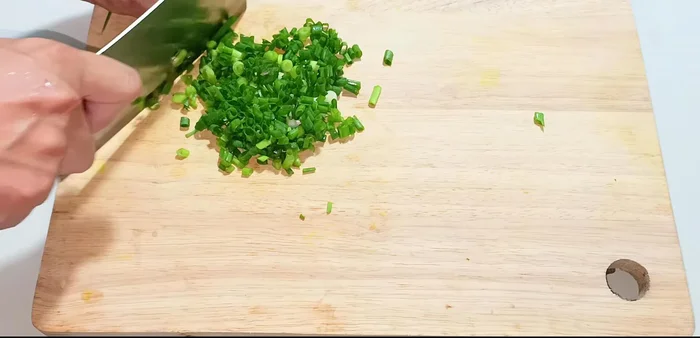 Chop green onions, cilantro, garlic, shallots, and ginger finely. (132.08)