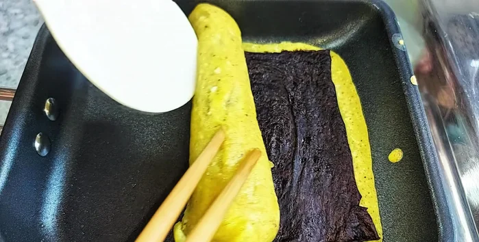 Place the egg rolls in the pan and cook until golden brown and crispy, adjusting heat as needed.
