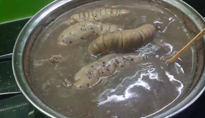 Boil the sausages in a pot of water, ensuring they are partially submerged. Let the water bubble vigorously five times. This cooking method prevents the sausages from bursting.