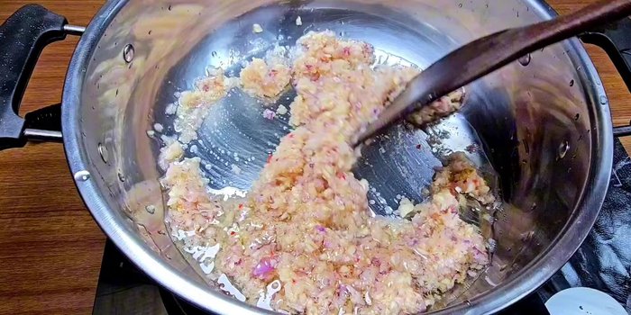 Sauté aromatics: Heat cooking oil in a pot and sauté the ground shallots, garlic, and chilies until fragrant and slightly cooked.