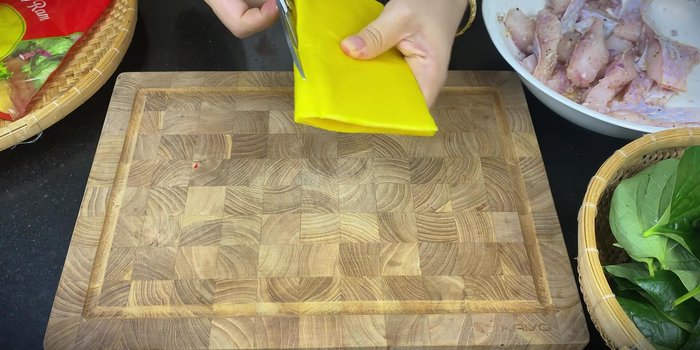 Assemble the spring rolls: Place a betel leaf on half of a spring roll wrapper. Add a piece of marinated fish, and roll it up. Secure the roll by tucking in the edges.