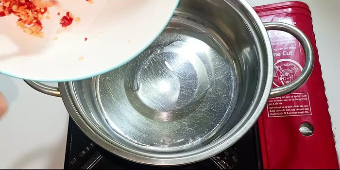 Heat a little cooking oil in a pot. Add minced garlic and chili, stir until golden and fragrant.