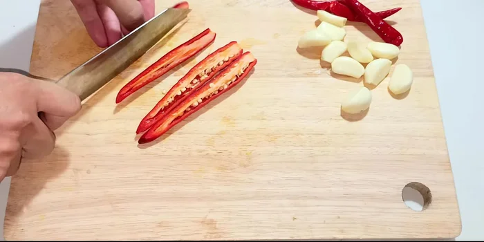 Cut the pineapple in half, remove the seeds, and cut into smaller pieces for easier blending.
