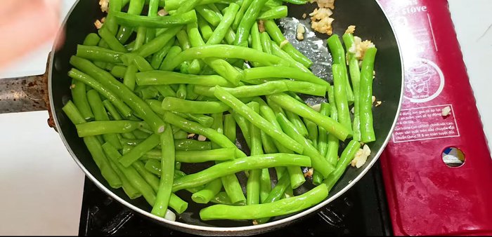 Pour in the sauce and stir-fry until the green beans are evenly coated. (211.36)