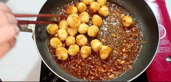 Reduce heat to low. Add the fried quail eggs and stir to coat with the sauce. Cook until the sauce reduces and clings to the eggs.