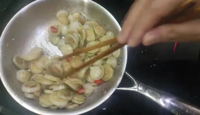 Once the eggplant is cooked and the water has dried up, add the betel leaves.