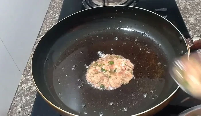 Pour the egg mixture into the hot oil and fry until golden yellow.
