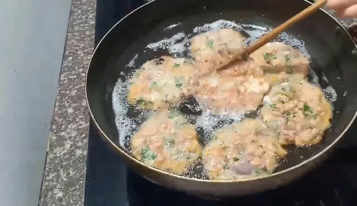Remove the fried fish egg rolls from the pan and place them on a plate lined with paper towels to drain excess oil.