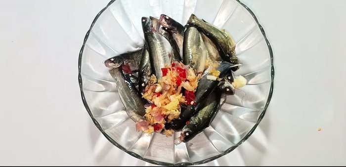 Marinate the fish with half of the blended mixture, sugar, seasoning powder, MSG, ground pepper, fish sauce, and caramel for 30 minutes. (Note: A caramel recipe link is provided in the video description)