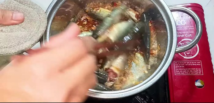 Add the marinated fish to the pot and stir-fry briefly to firm and flavor the fish.