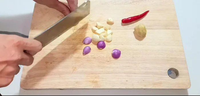 Cut remaining ingredients (shallots, garlic, tuber, chili) into small pieces and blend or grind in a mortar. Do not puree completely.