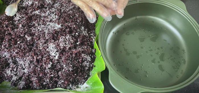 Roll the sticky rice into balls, ensuring cleanliness to prevent infection. Sprinkle with the salt water mixture.
