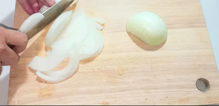 Prepare the ingredients: Cut the onion into thin slices and soak in ice water to reduce pungency. Cut the chili in half; use half for strips in the salad and half (minced with garlic) for the dipping sauce. Clean and chop basil, water spinach.