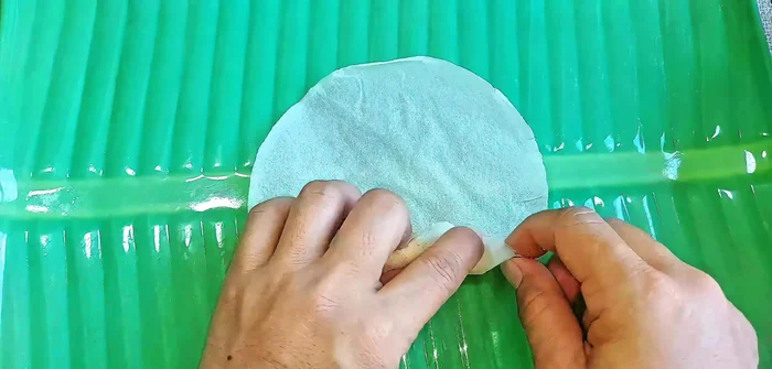 Place a rice paper wrapper on a flat surface, add a chickpea ball to the center, and wrap tightly.