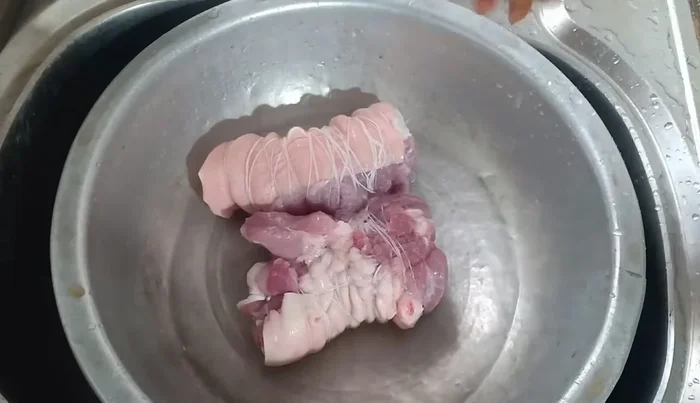 Transfer the boiled pig's feet to a pot.