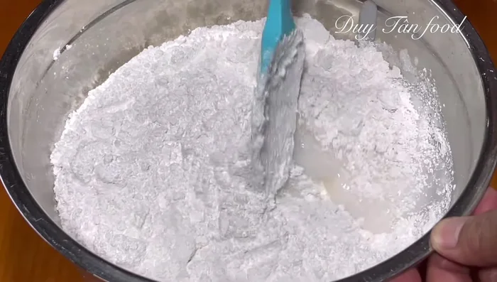 Combine dough ingredients: Add 600g sticky rice flour to the hot liquid and stir until well combined. Knead the dough until it's soft and smooth, about 5-7 minutes.