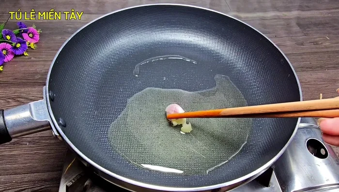 Heat a pan and add cooking oil. Add crushed garlic cloves (optional) to enhance the aroma.
