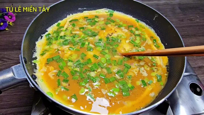 As the eggs begin to set, use chopsticks to gently poke holes to allow the liquid egg to flow underneath, preventing burning and ensuring even cooking.