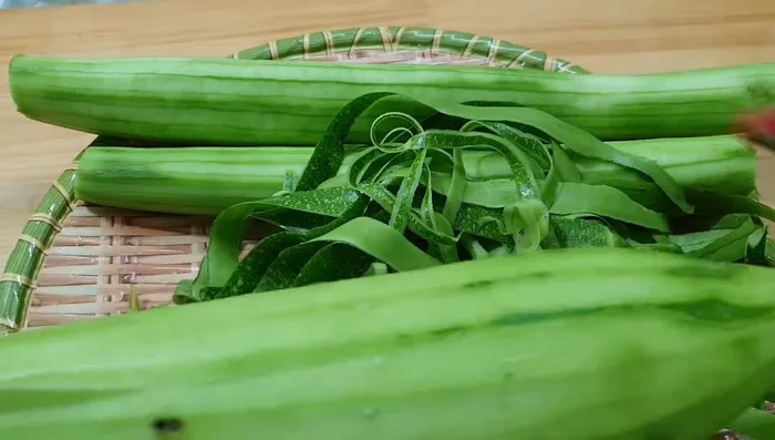 Prepare the ingredients: Peel and cut the squash into small pieces. Shred the bottle gourd using a grater.