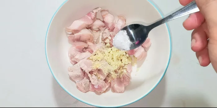 Marinate the pork: In a bowl, combine half the minced garlic with the sliced pork, seasoning powder, MSG, sugar, fish sauce, and ground pepper. Marinate for 15-20 minutes.