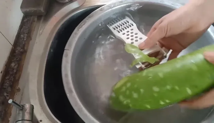 Peel the gourd, scraping only the outer shell to preserve the green pulp inside. This prevents the sap from sticking to your hands.