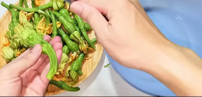 Prepare squash buds: Remove green parts, stamens, and peel off the tough outer layer. Wash and drain.