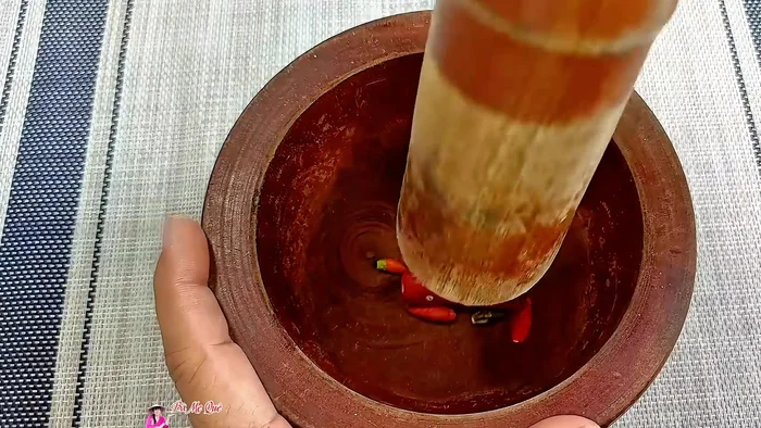 Pound garlic and chili (optional): Pound garlic and chili peppers together. If not using garlic, pound only the chilies.