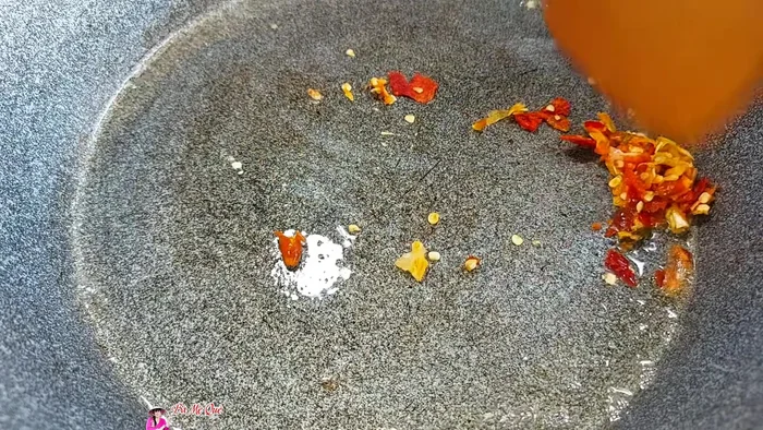 Fry the garlic and chili: Fry the pounded garlic and chili in a pan with oil until fragrant and golden brown.