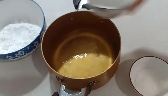 Boil water in a pot. Add 1 tablespoon of sugar to the boiling water and stir until dissolved.