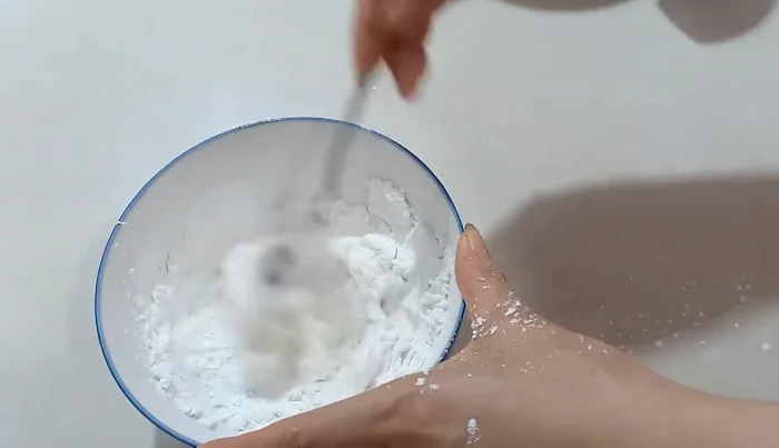 Knead the mixture with a spoon until it forms a dough. Once it cools slightly, knead it by hand until it's no longer sticky.