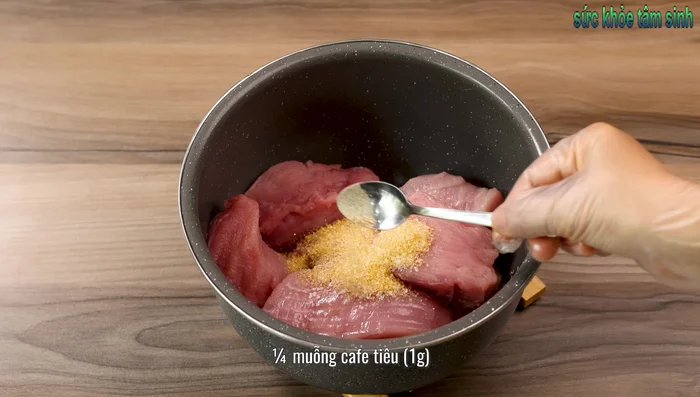 Marinate the pork in the rice cooker with salt, sugar, pepper, shallots, and optional honey for 30 minutes, mixing occasionally.