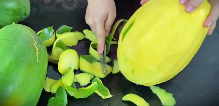 Peel, wash, and shred the papaya. Press down on the peeling table to make the fibers a little bigger.