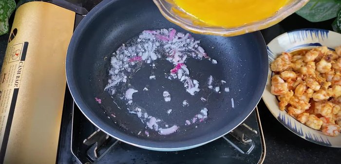 Pour a portion of the whisked eggs into the pan. Cook over low heat until set, but still slightly runny on top.