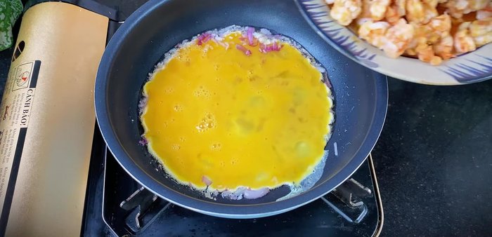 Add a portion of the cooked shrimp to the egg.