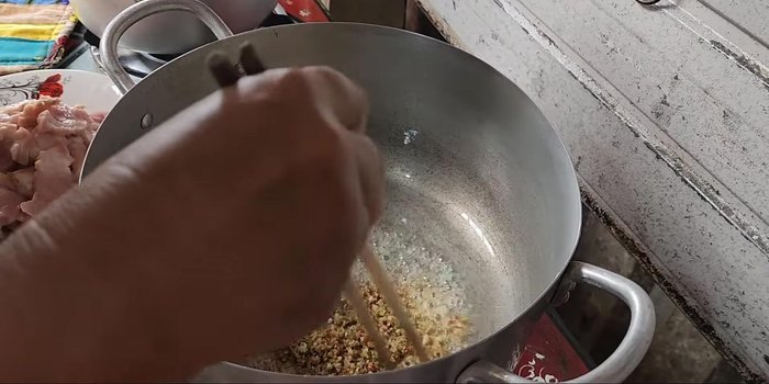 Heat oil and sauté aromatics: Heat oil in a pot and sauté garlic, lemongrass, and chili until fragrant. Add purple shallots.
