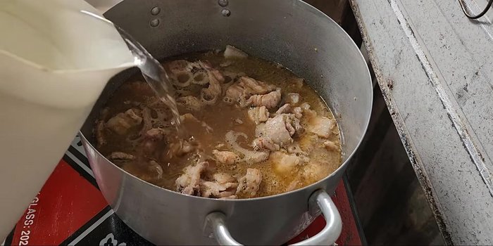 Add coconut water and simmer: Add coconut water and bring to a boil. Skim off any foam that forms.