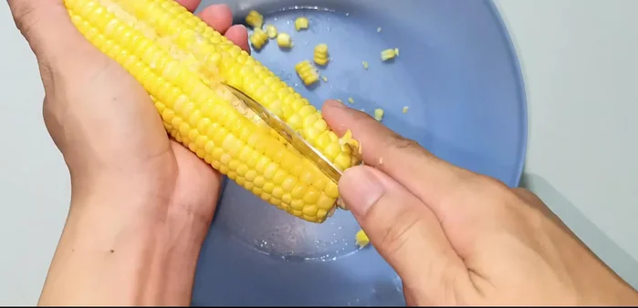 Prepare corn: Cut the corn kernels off the cob using a knife. (118.92)