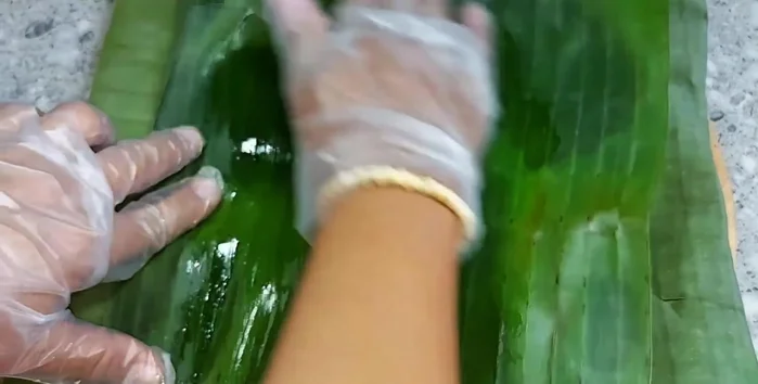 Wrap the mixture in banana leaves, ensuring it's not too tight to allow steam to reach the inside. Use cooking oil to prevent sticking.