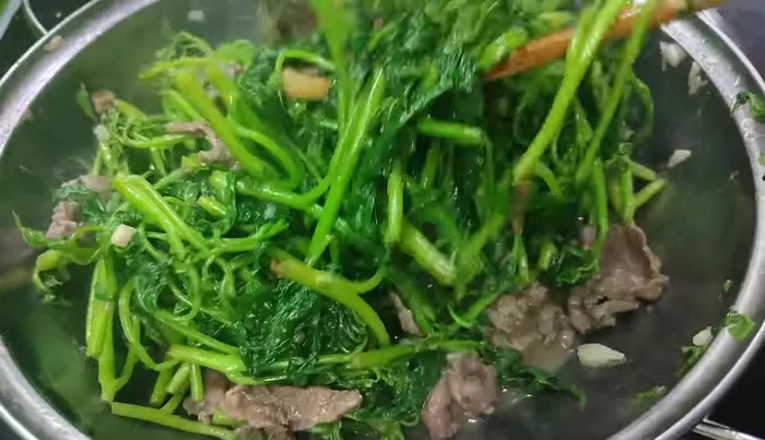 Return the stir-fried buffalo meat to the wok and combine with the vegetables.