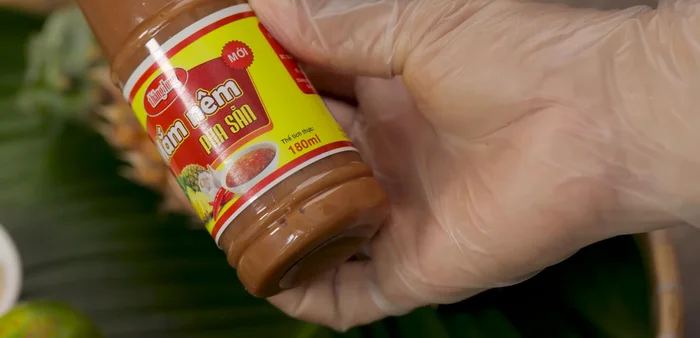 Prepare the dipping sauce: Grate the pineapple, removing the core. Mix it with fish sauce, rock sugar, lemon juice, minced chili, minced garlic, and coconut water. Stir until sugar dissolves.