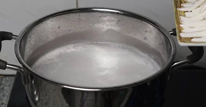 Add noodles to the boiling broth. Skim off any foam. Add stir-fried shrimp and meat.