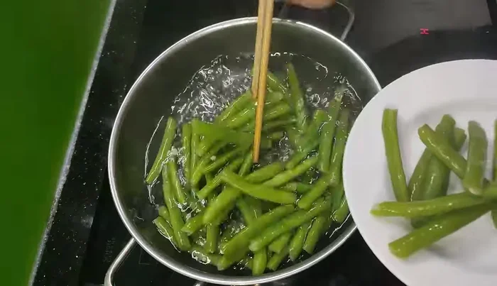 Boil vegetables (e.g., beans).