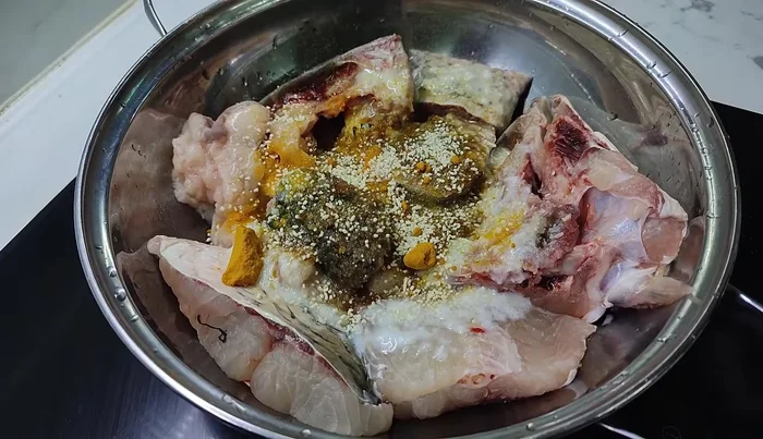 Marinate the fish head, tail, and less meaty parts with shrimp paste, salt, lemongrass, MSG, turmeric, and chili. If you don't use much salt, add soy sauce.