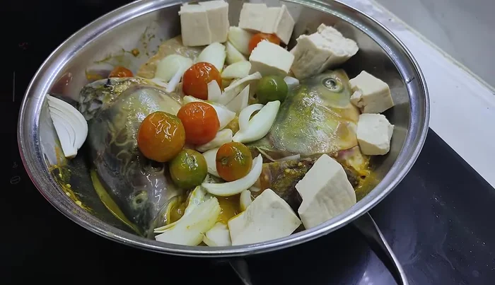 After marinating, add tomatoes and beans to the fish.