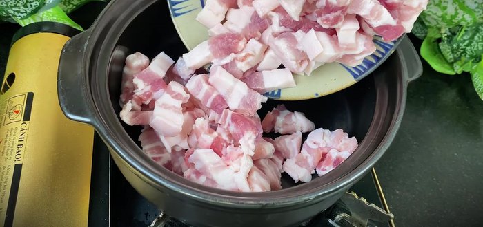Brown the pork belly in a pot over high heat, then reduce heat and simmer until the fat renders and the meat is nicely browned.