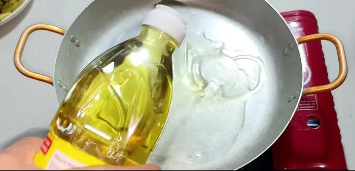 Heat cooking oil in a pan over medium heat. Add garlic and shallots, stir until fragrant and golden brown.