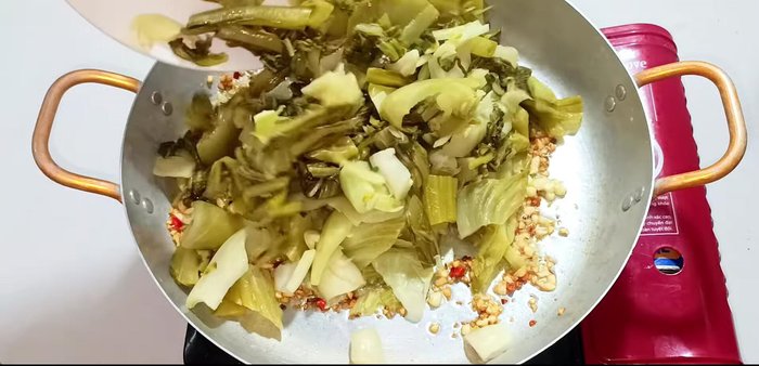 Add the pickled cabbage and stir-fry until evenly coated with oil, garlic, and chili.
