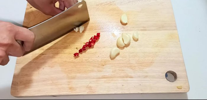 Chop garlic and chili peppers together.