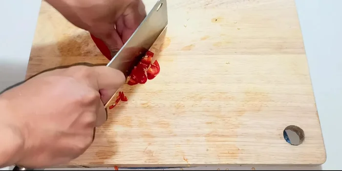 Halve the chili peppers, remove seeds, and chop finely. Add two more chili peppers for mild spiciness.