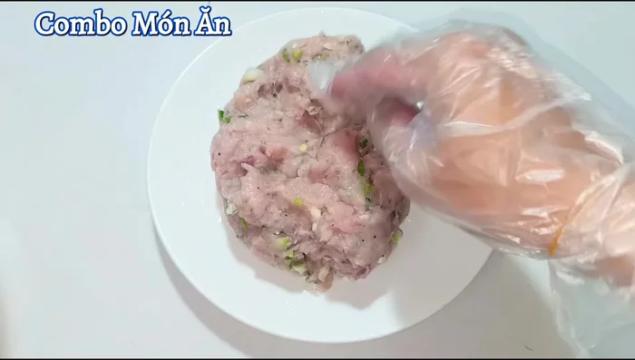 Shape the fish cake mixture into a ball, then spread it evenly on an oiled plate, decorating it with sliced chili peppers.
